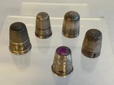 several thimbles are on display on a glass surface