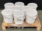 plusieurs seaux de peinture blanche posés sur une palette en bois