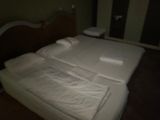 un lit recouvert de draps blancs dans une pièce sombre