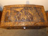 a wooden box with carvings on it sitting on the floor