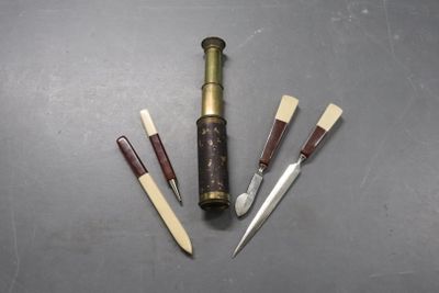 trois types de couteaux différents et une bouteille de vin posés sur une table