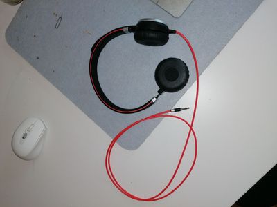 a mouse, headphones, and a mouse pad on a desk