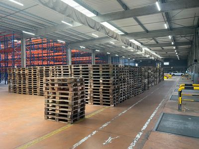 un grand entrepôt rempli de palettes et de cartons