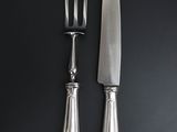 two forks and a knife on a black surface