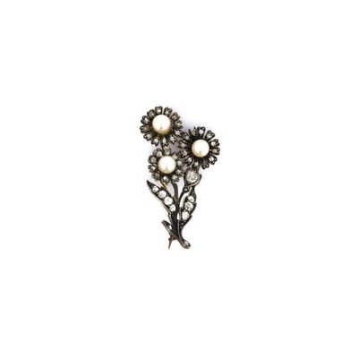 un gros plan d'une broche ornée de perles sur fond blanc