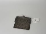 an old purse with a tag on it sitting on a table