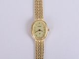 an image of a gold wrist watch with a chain around it
