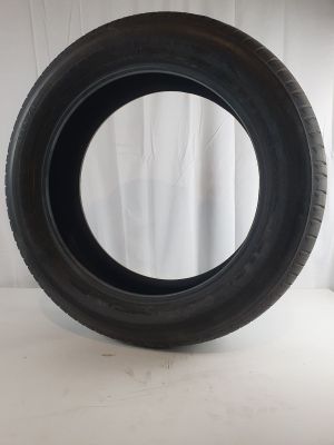 a close up of a tire on a white surface with a curtain behind it