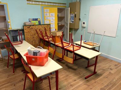 une salle où se trouvent plusieurs bureaux et chaises