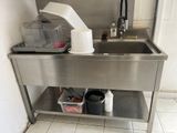 a stainless steel sink in the corner of a kitchen