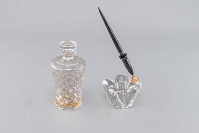 a small glass bottle with a pen next to it