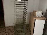 an image of a kitchen with a metal rack and a refrigerator