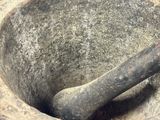 a mortar with a wooden handle in the middle of it