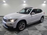 the bmw x1 is parked in a large room with a checkered floor