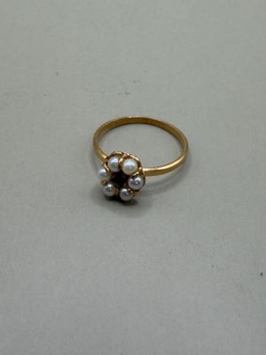 a gold ring with pearls on it on a table