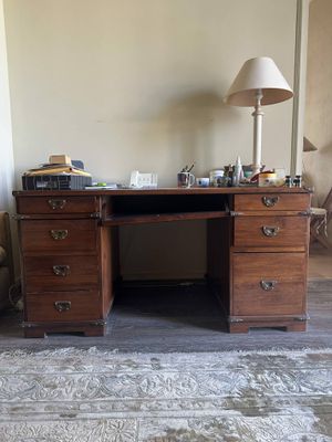 a desk with a chair and a lamp in a room