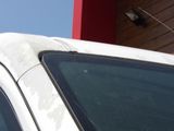 a cat sitting on the roof of a car in front of a building