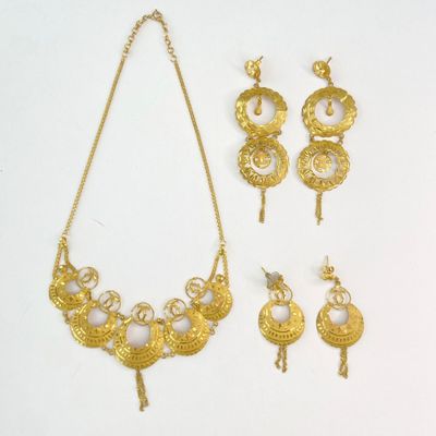 three pieces of gold jewelry including a necklace, earrings and a ring