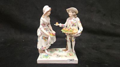 deux figurines représentant deux femmes ornées de fleurs