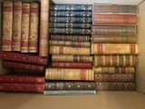 une boîte pleine de vieux livres posée sur le sol