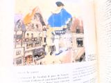un livre ouvert sur lequel figure la photo d'un homme en chemise bleue