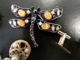 a dragonfly brooch and a pair of earrings on a table
