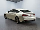the rear end of a white audi sedan parked in a garage