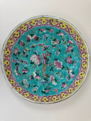 une assiette avec des fleurs et des oiseaux sur une table
