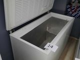 a white chest freezer sitting on a wooden floor