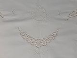 a close up of a white table cloth with a design on it
