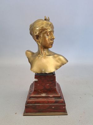 buste en laiton représentant une femme coiffée d'une couronne, posé sur un socle en marbre