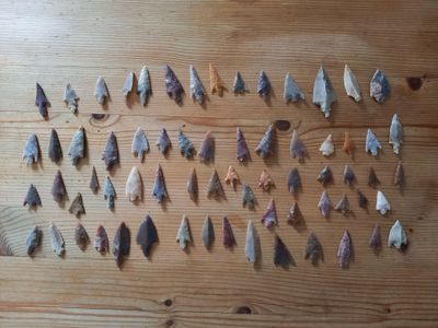 de nombreux types de flèches posés sur une table en bois