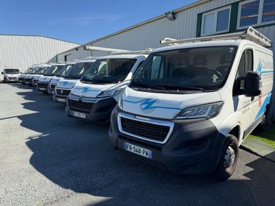 many white vans parked in a row in a parking lot
