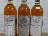 trois bouteilles de vin posées sur une table en bois
