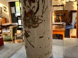 a person that is holding a vase on a table