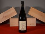 a bottle of wine sitting on a table next to two wooden boxes