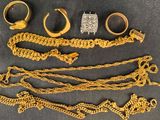 several gold rings and bracelets are laid out on a table