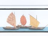 deux petits bateaux dans une vitrine posée sur une table