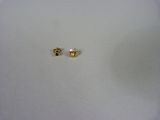 two small gold stud earrings sitting on top of a white surface