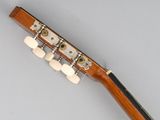 a close up of a guitar neck with four strings on a gray surface