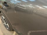 a car that has been dented and is parked on the side of the street