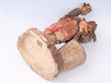 a figurine of a man playing a drum on a white surface