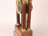 a clock that is sitting on top of a wooden stand