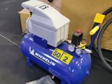 un compresseur d'air bleu posé par terre à côté d'un vélo
