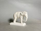 statue of an elephant on a white base against a gray background