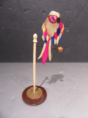 a bird that is sitting on a stand with a ball