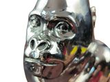 a silver statue of a gorilla on a black stand