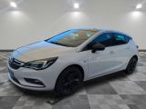 a white opel parked on a checkered floor in a garage