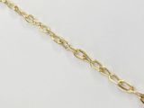 gros plan d'un bracelet en chaîne en or sur une surface blanche