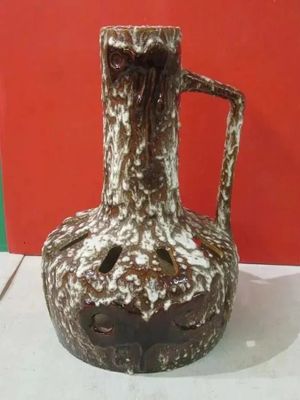 a brown and white vase sitting on a table